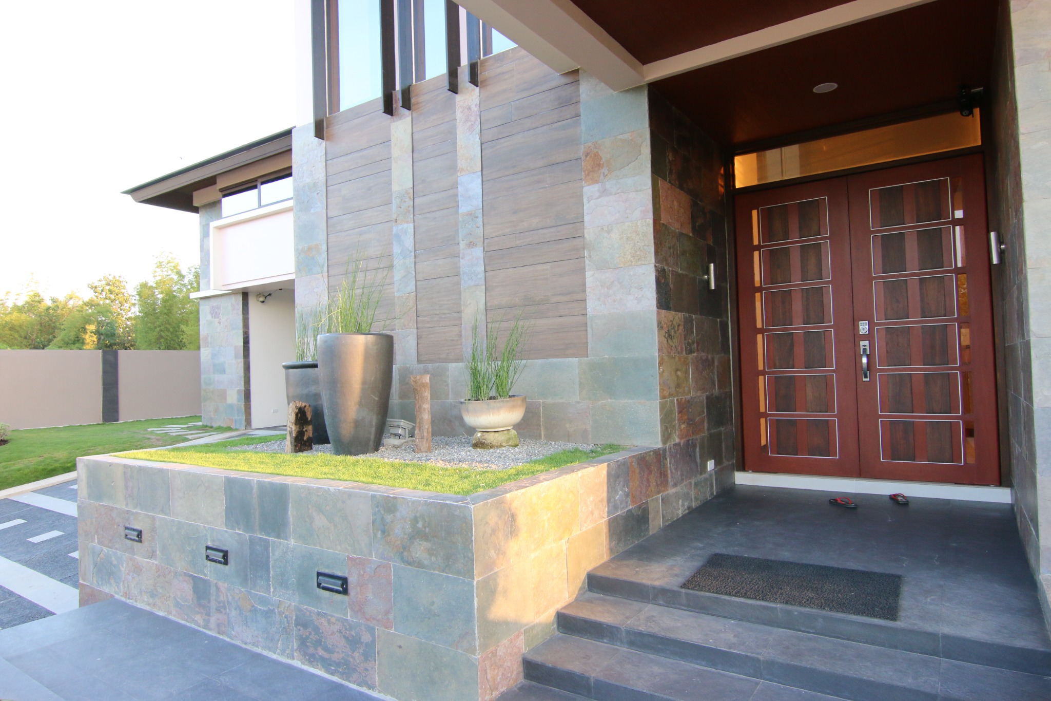 Close view of a residential entrance, stone finishes and timber doors
